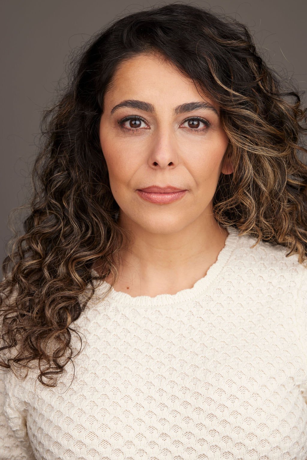Azadeh Zanjani headshot with long curly hair